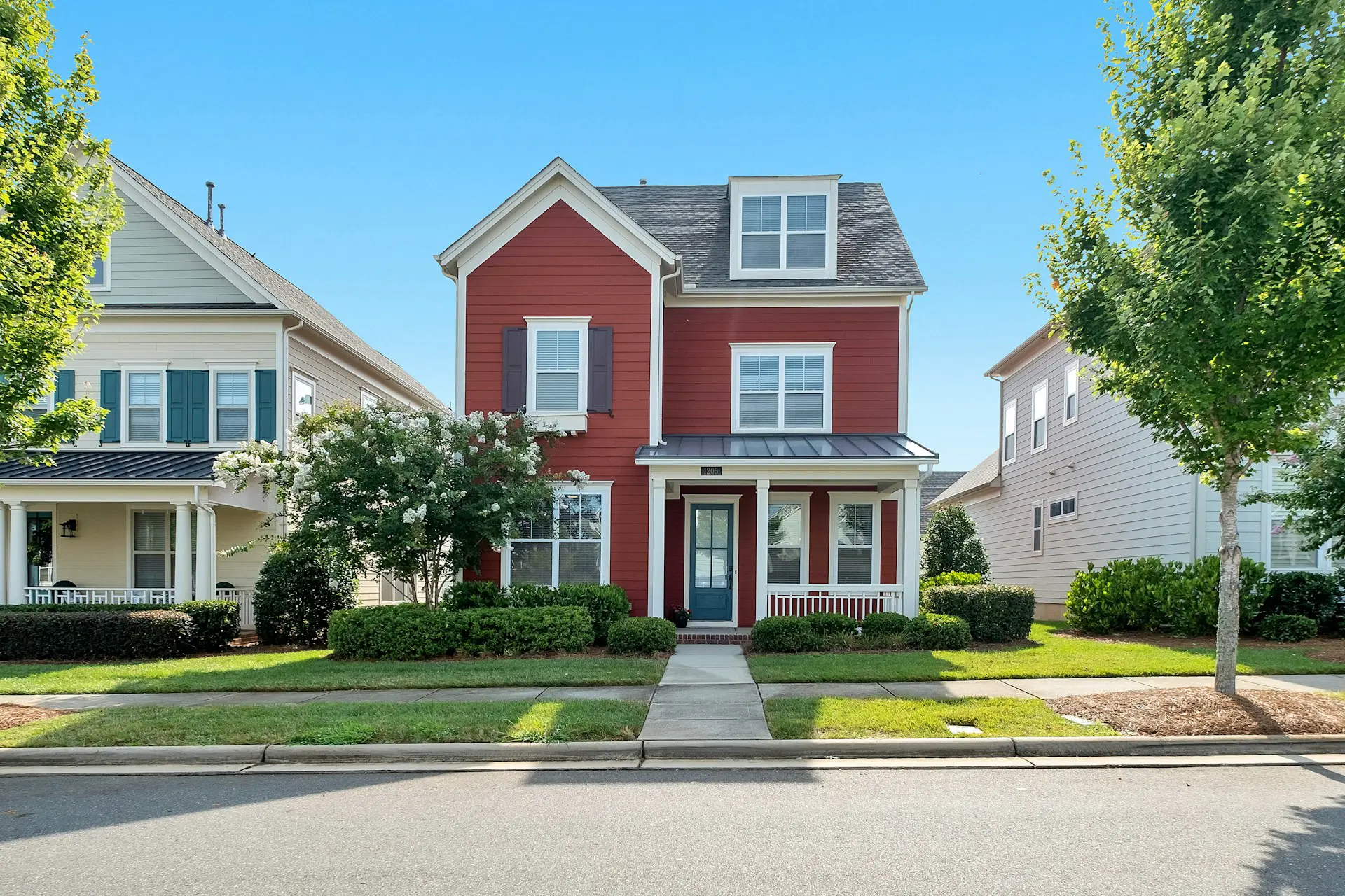A red two-story house with a front porch